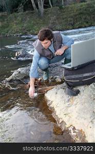 Man scientist testing quality of water in river