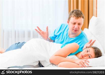 man scolds his wife in bed at night