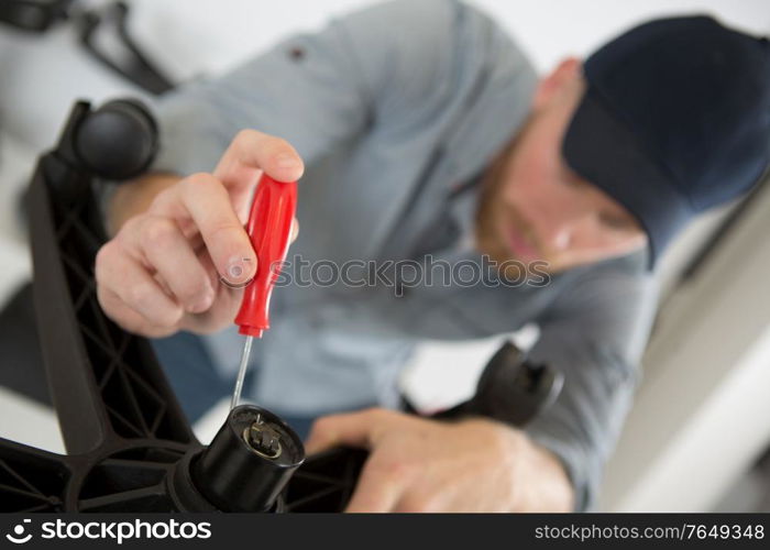 man screwing a chair with key