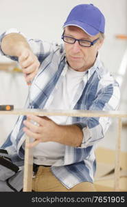 man screwing screws into furniture fittings