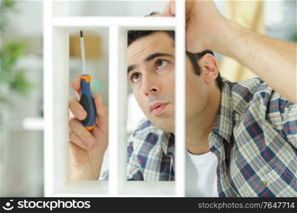 man screwing screws into furniture fittings closeup