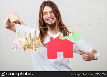 Man seller with money and house. Concept of real estate and deal. Seller man with house model and banknotes. Selling and buying proposition.