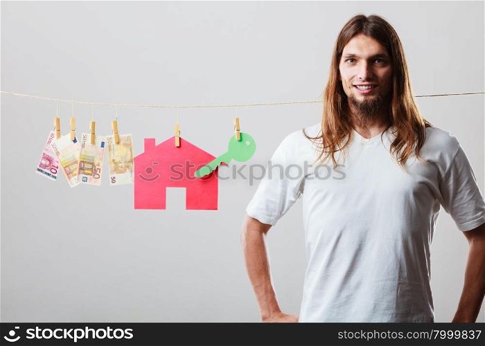 Man seller with money and house. Concept of real estate and deal. Seller man with house model and banknotes. Selling and buying proposition.