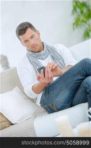 Man sending a text message from home