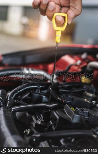 Man service mechanic maintenance inspection service maintenance car Check engine oil level car in garage showroom dealership blurred background.