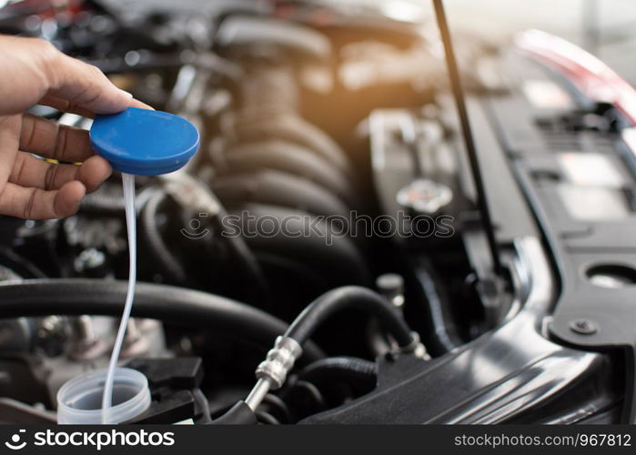 Man service mechanic maintenance inspection service maintenance car Check engine with fill water add water to the wiper car in garage showroom dealership blurred background For automotive automobile