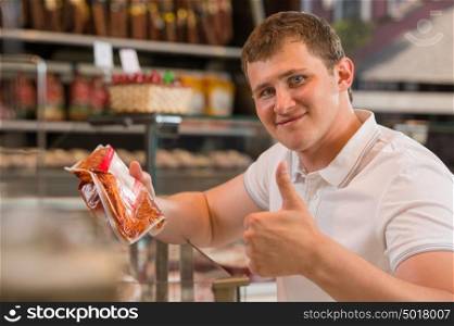 Man shopping at the supermarket buying meat
