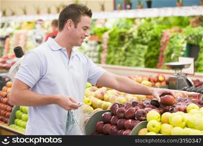 Man shopping for apples at a grocery store