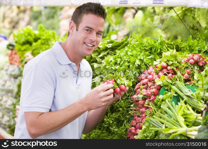 Man shopping for beets at a grocery store