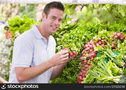 Man shopping for beets at a grocery store