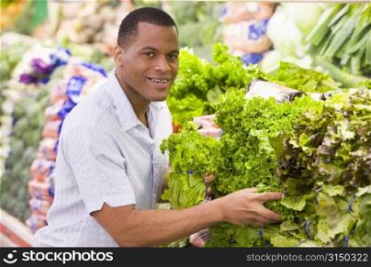 Man shopping for lettuce at a grocery store