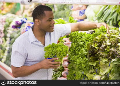 Man shopping for lettuce at a grocery store