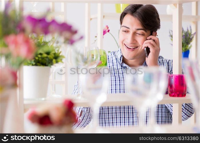 Man shopping in shop and calling his wife