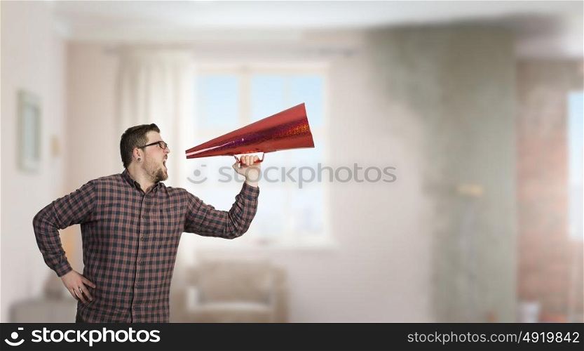 Man shouting in pape cone. Guy in shirt andf glasses make announcement in trumpet