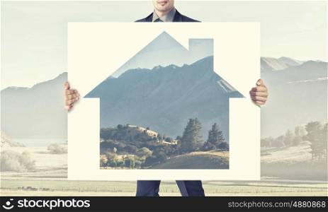 Man show banner with construction concept. Businessman in suit holding placard with house symbol