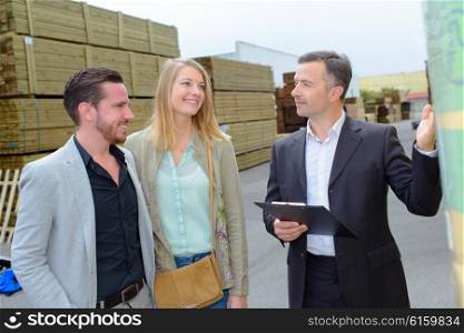Man showing couple around a builder&rsquo;s yard