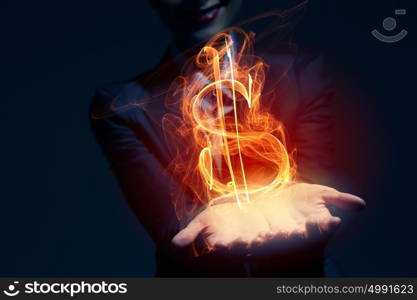 Man showing dollar symbol. Burning dollar sign in businessman palm on dark background