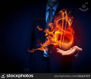 Man showing dollar symbol. Burning dollar sign in businessman palm on dark background