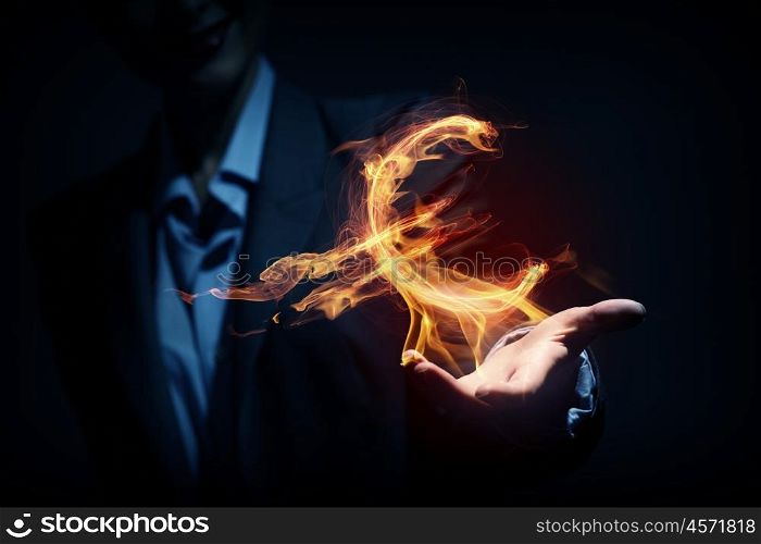Man showing dollar symbol. Burning euro sign in businessman palm on dark background