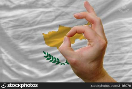 man showing excellence or ok gesture in front of complete wavy cyprus national flag of symbolizing best quality, positivity and succes