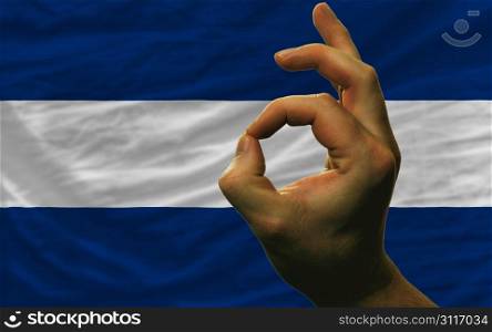 man showing excellence or ok gesture in front of complete wavy nicaragua national flag of symbolizing best quality, positivity and succes
