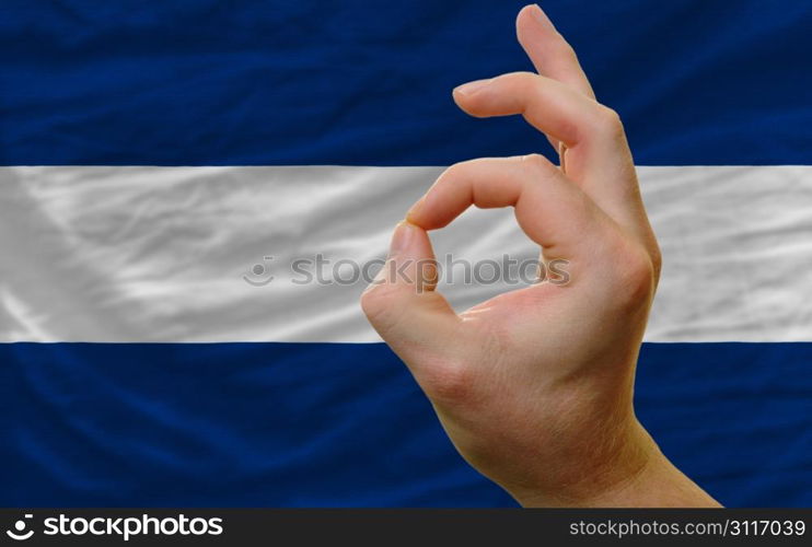 man showing excellence or ok gesture in front of complete wavy nicaragua national flag of symbolizing best quality, positivity and succes