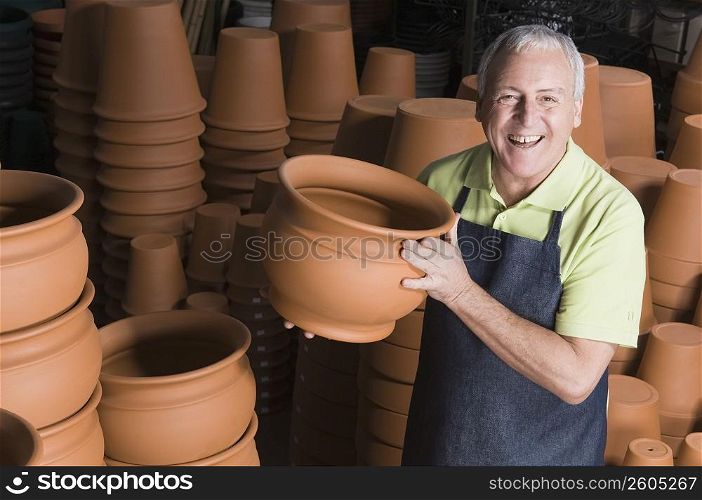 Man showing flower pot in a garden center