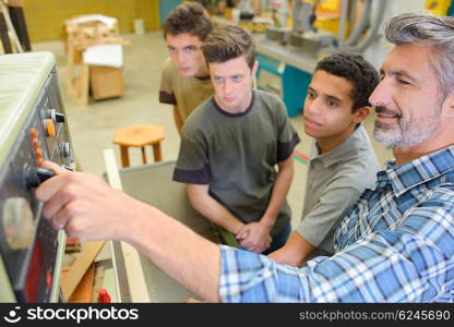 Man showing how to start machine in workshop