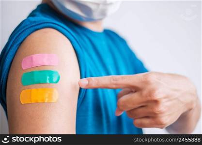 Man showing plaster after receiving covid 19 vaccine. Vaccination, herd immunity, side effect, booster dose, vaccine passport and Coronavirus pandemic