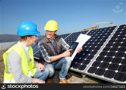 Man showing solar panels technology to student girl