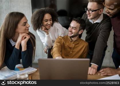 man showing something his colleagues laptop during meeting