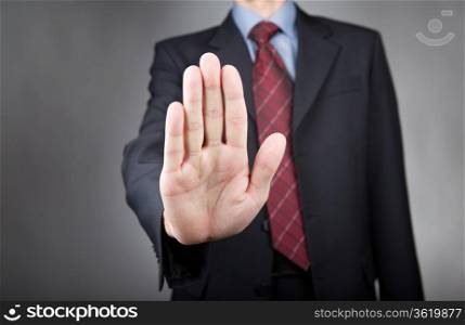 Man showing stop gesture. Neutral background