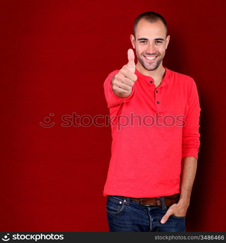 Man showing thumb up on red background