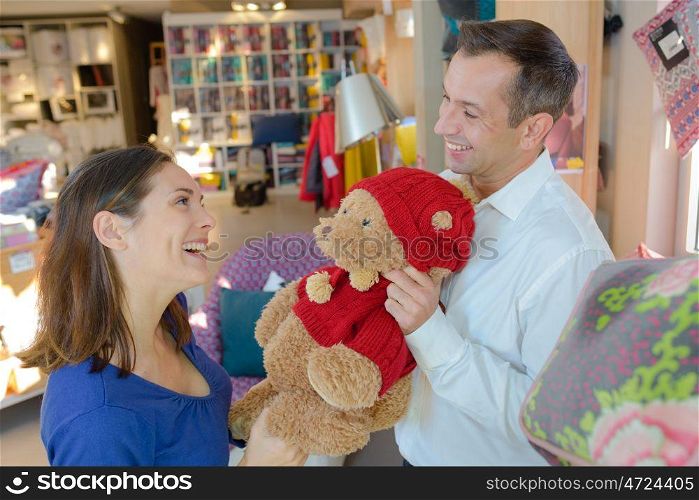 Man showing woman a teddy bear