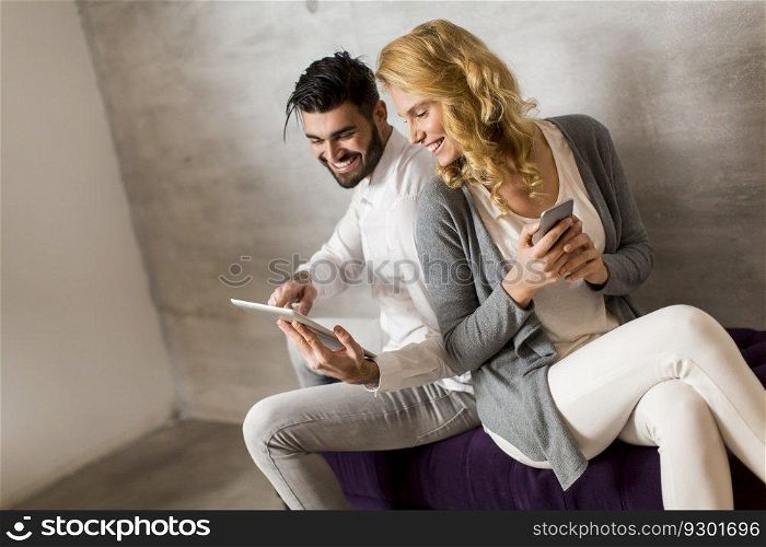 Man showing woman information on tablet and girl holding smartphone