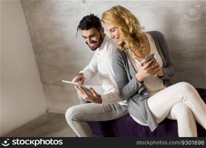 Man showing woman information on tablet and girl holding smartphone