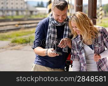 Man showing woman pictures on digital camera vacation couple smiling