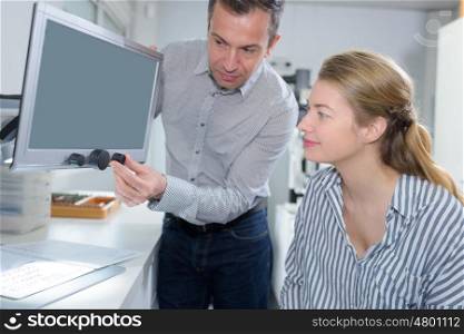man showing woman screen mechanism