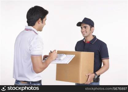 Man signing for package from delivery man against white background