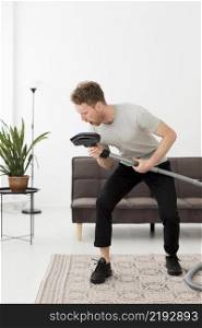 man singing vacuum while cleaning