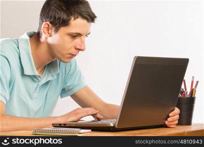Man siting at desk working in a laptop pc