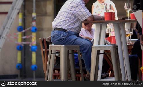 Man sits at a table drinking wine in the afternoon