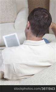 Man sits reading a digital book