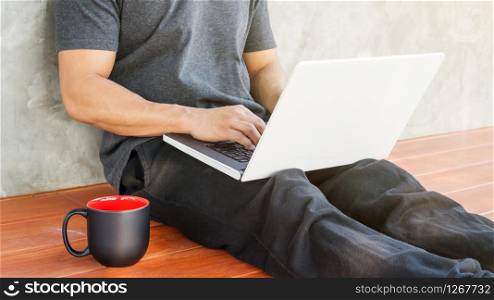 Man sitting and use a white laptop.