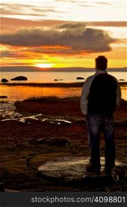 Man sitting and watching a beautiful sunrise