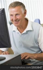 Man sitting at a computer terminal typing (high key)