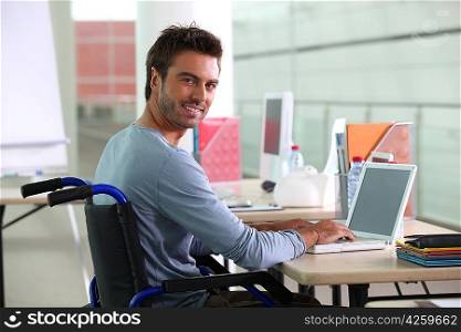 Man sitting at desk in wheelchair