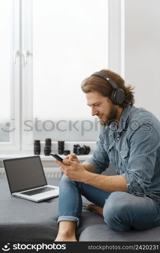 man sitting couch with smartphone