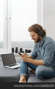 man sitting couch with smartphone