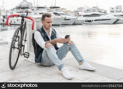 man sitting his bike playing phone